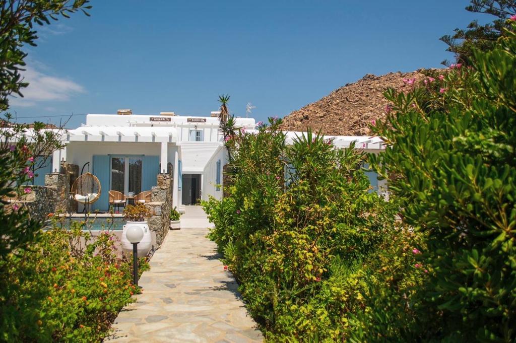 una casa bianca con un sentiero che la porta di Agrari Ninemia Mykonos ad Agrari