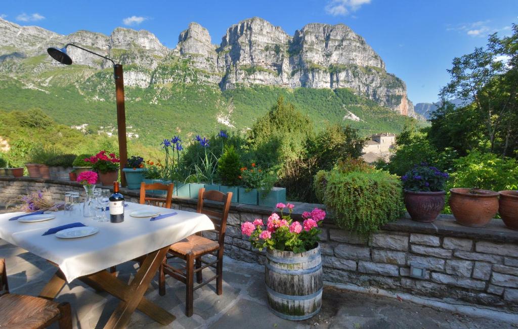 a table and chairs with a mountain in the background at Pantheon in Papingo