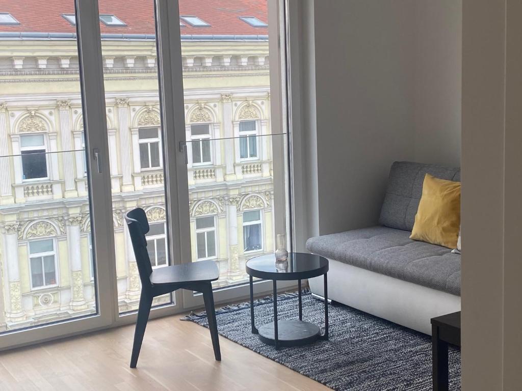 uma sala de estar com um sofá, uma mesa e uma janela em Urban Lifestyle em Viena