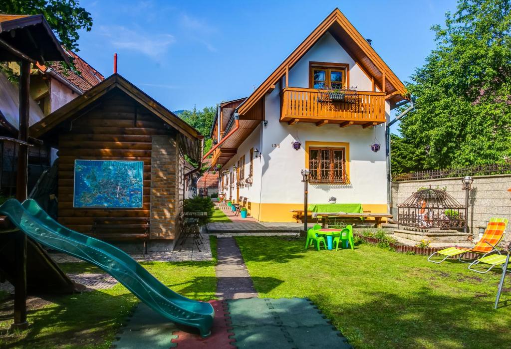 a house with a slide in the yard at Penzión Aurel in Liptovský Ján