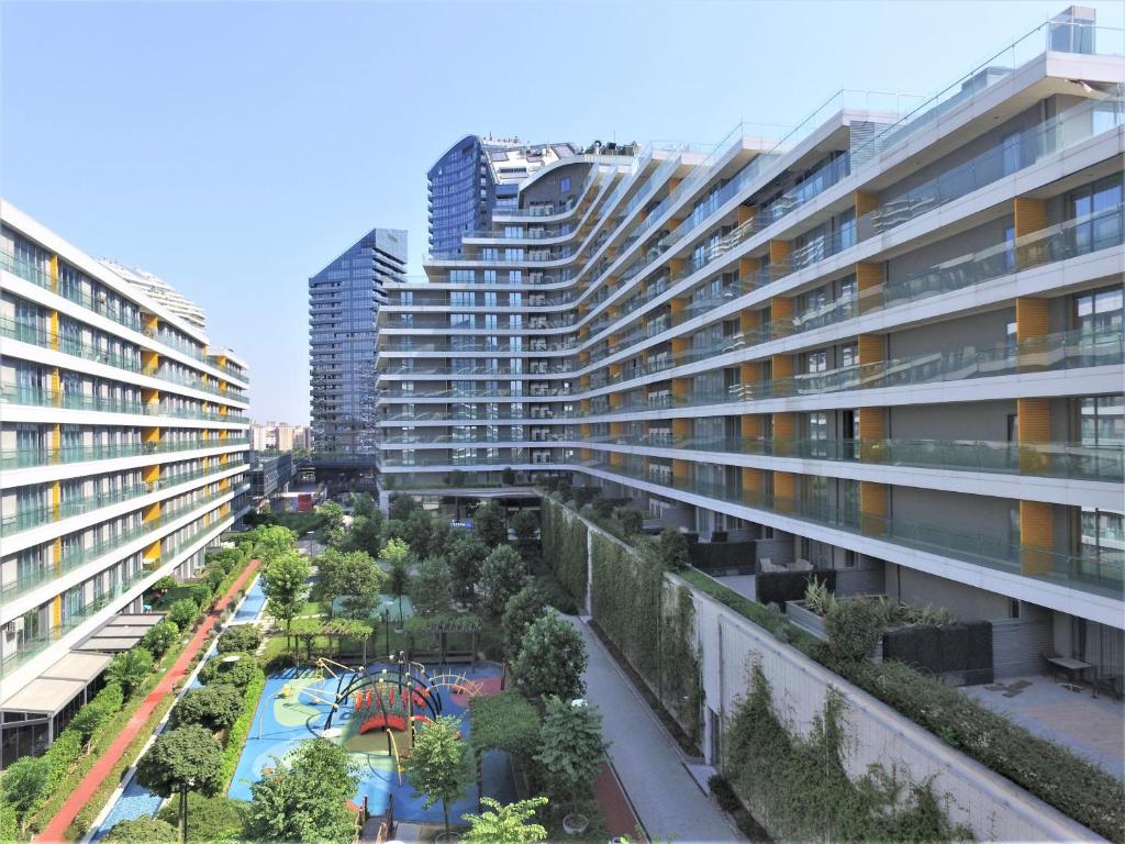 um edifício de apartamentos com um jardim e um parque infantil em The Superior Living Batışehir em Istambul