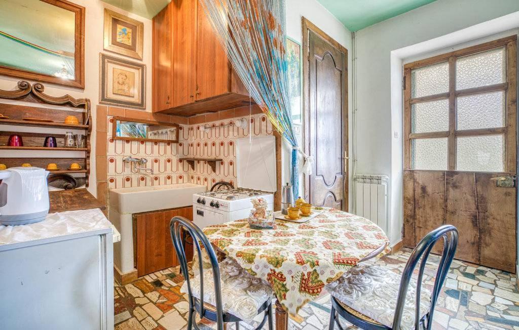 kuchnia ze stołem i krzesłami w pokoju w obiekcie B&B I Colori dell'Arcobaleno w mieście Belvedere Langhe