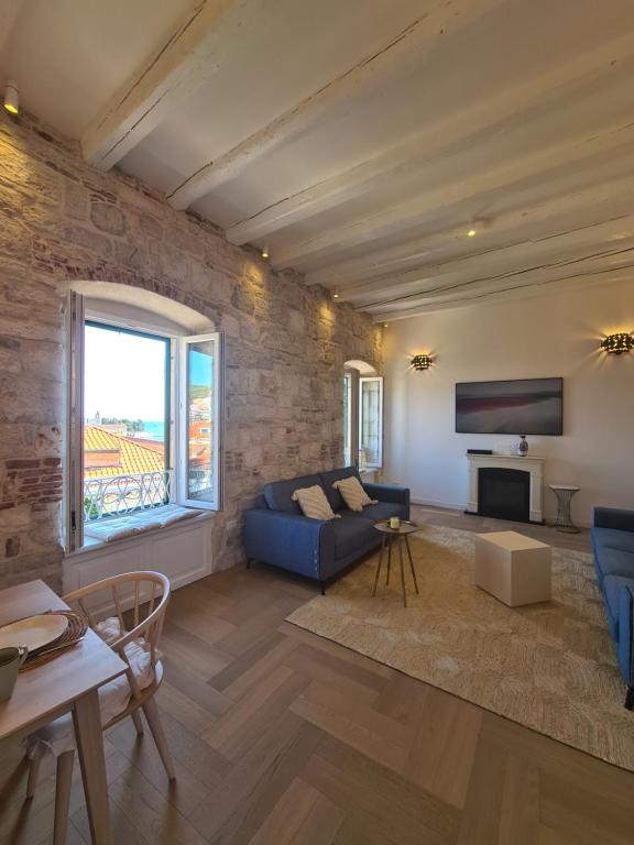 a living room with a blue couch and a tv at Apartment Tomazina (seaview,central, heritage) in Vis