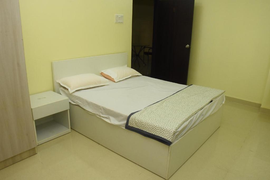 a small bedroom with a bed with a night stand at SWEET HOMES in Hyderabad