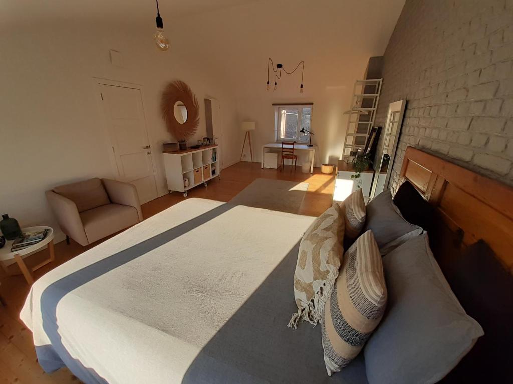 ein Schlafzimmer mit einem großen Bett und einer Ziegelwand in der Unterkunft Office des bons enfants in Huy
