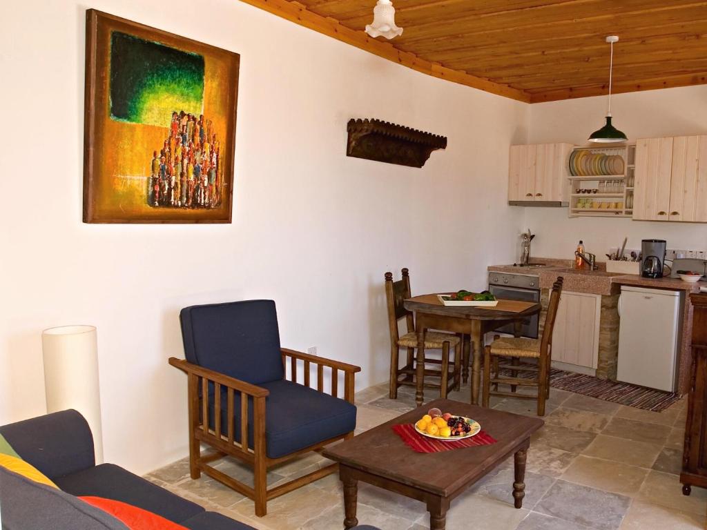 a living room with a table and a kitchen at Eveleos Country House in Tochni