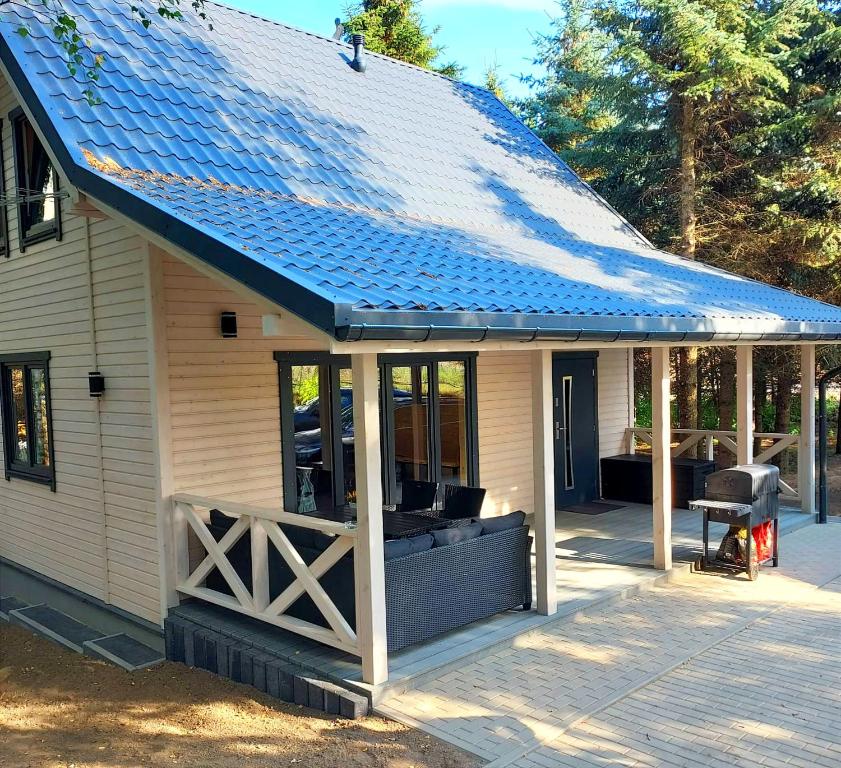 eine abgeschirmte Veranda mit blauem Dach in der Unterkunft Świerkowisko cisza las plaża blisko in Ostróda