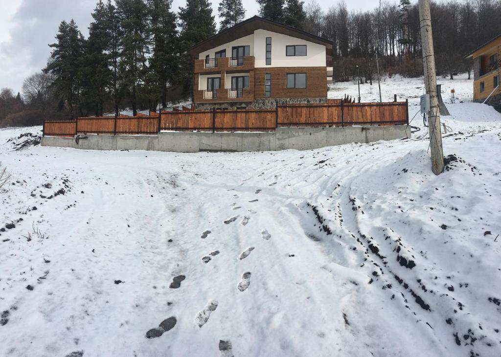 una casa en la nieve con huellas en la nieve en House Near Forest, en Bakuriani