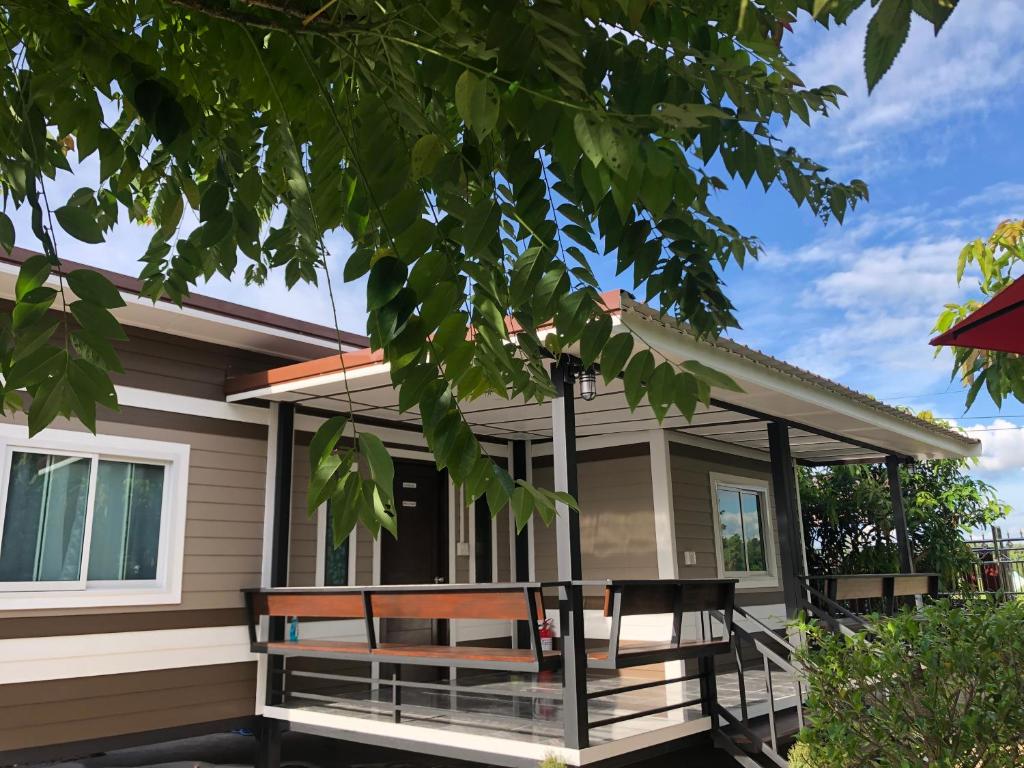 ein Haus mit einer Veranda mit einer Hollywoodschaukel in der Unterkunft Sukanya Guesthouse 