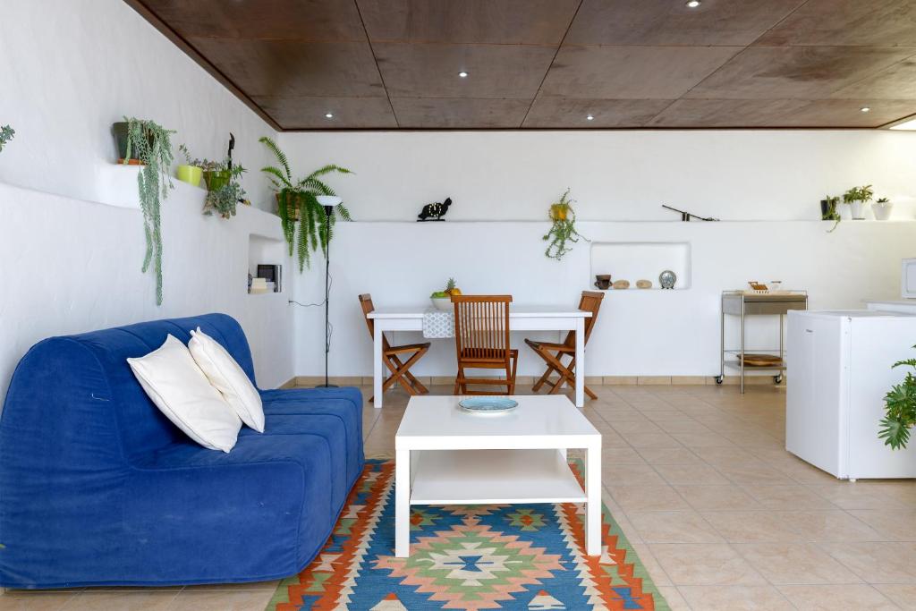 - un salon avec un canapé bleu et une table dans l'établissement Tahiche Vistas, à Tahiche