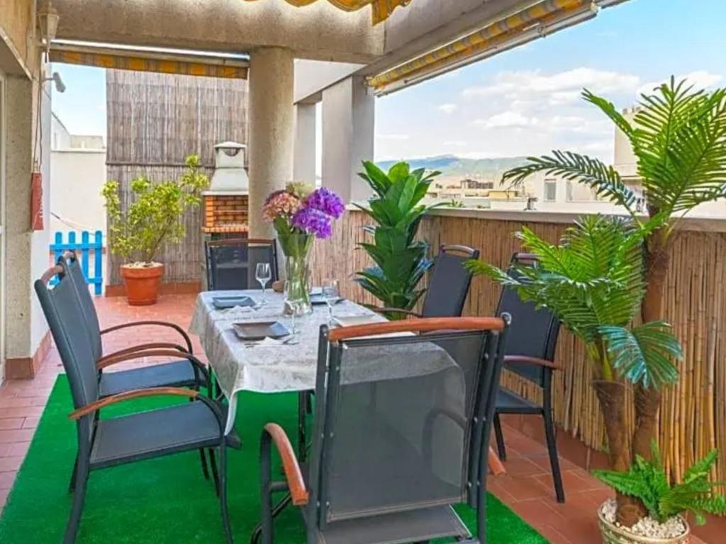 un patio con mesa, sillas y plantas en Lujoso Atico playa-parking gratis, en Málaga