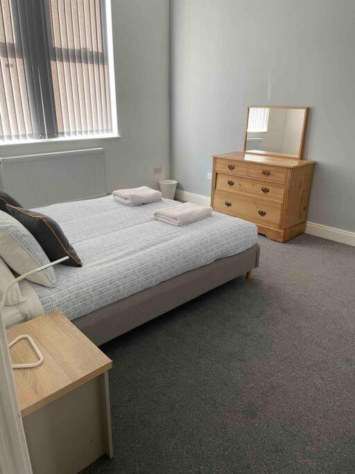 a bedroom with a bed and a wooden dresser at Newly refurbished one bedroom apartment in Preston