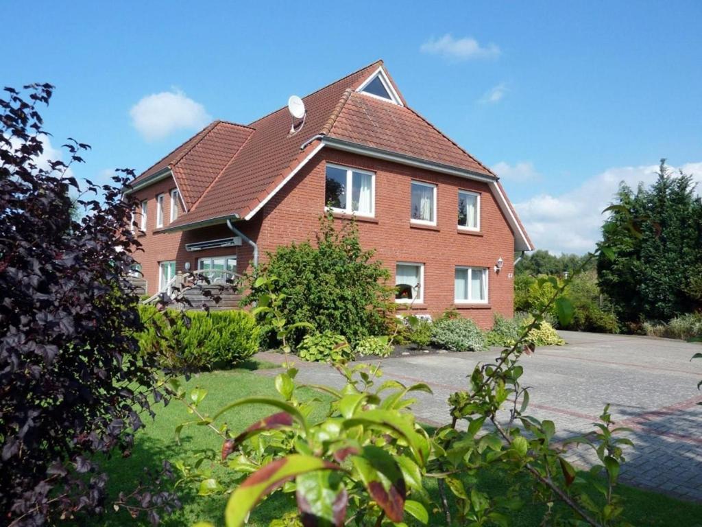 a brick house with a brown roof at FeWo Marianne in Neukamperfehn