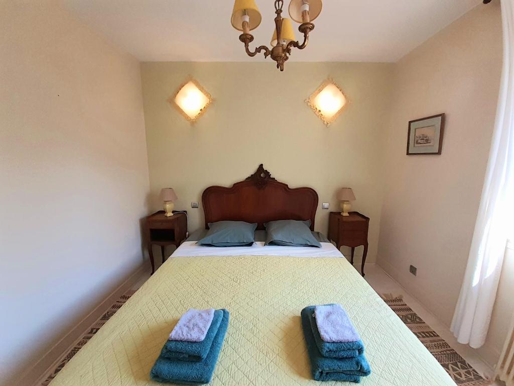 ein Schlafzimmer mit einem Bett mit zwei Handtüchern darauf in der Unterkunft Maison centre-ville avec jardin privé Jonzac in Jonzac