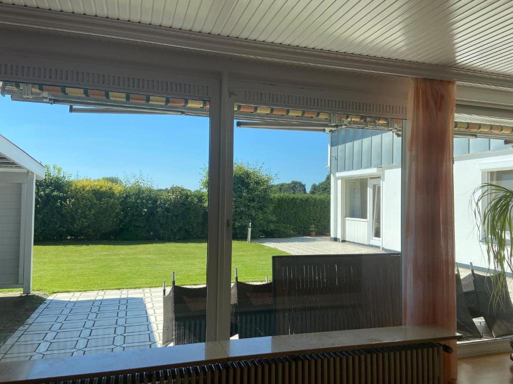 a screened in porch with a view of a yard at Ferienhaus direkt an der Luhe in Winsen