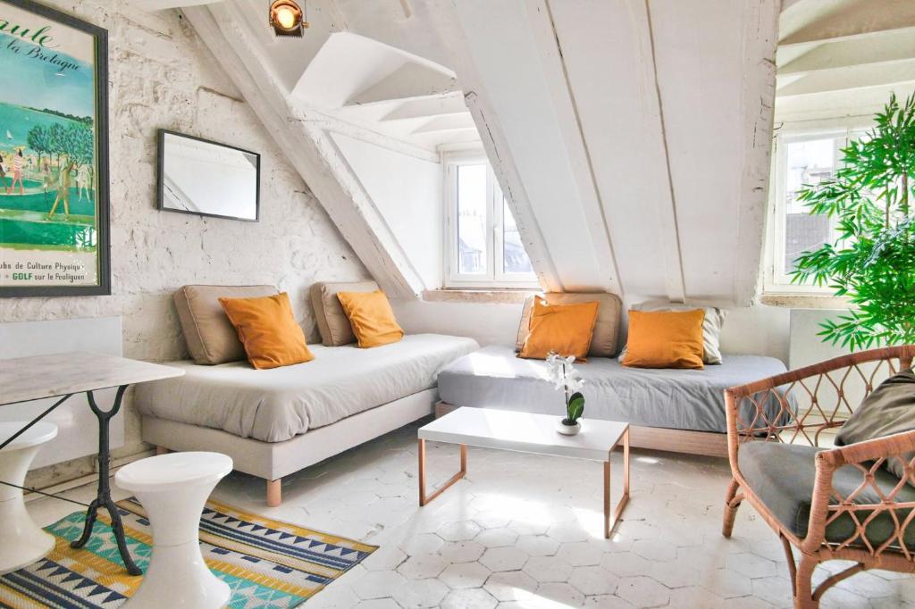 ein Wohnzimmer mit 2 Sofas und einem Tisch in der Unterkunft Studio Chatelet Lescot in Paris