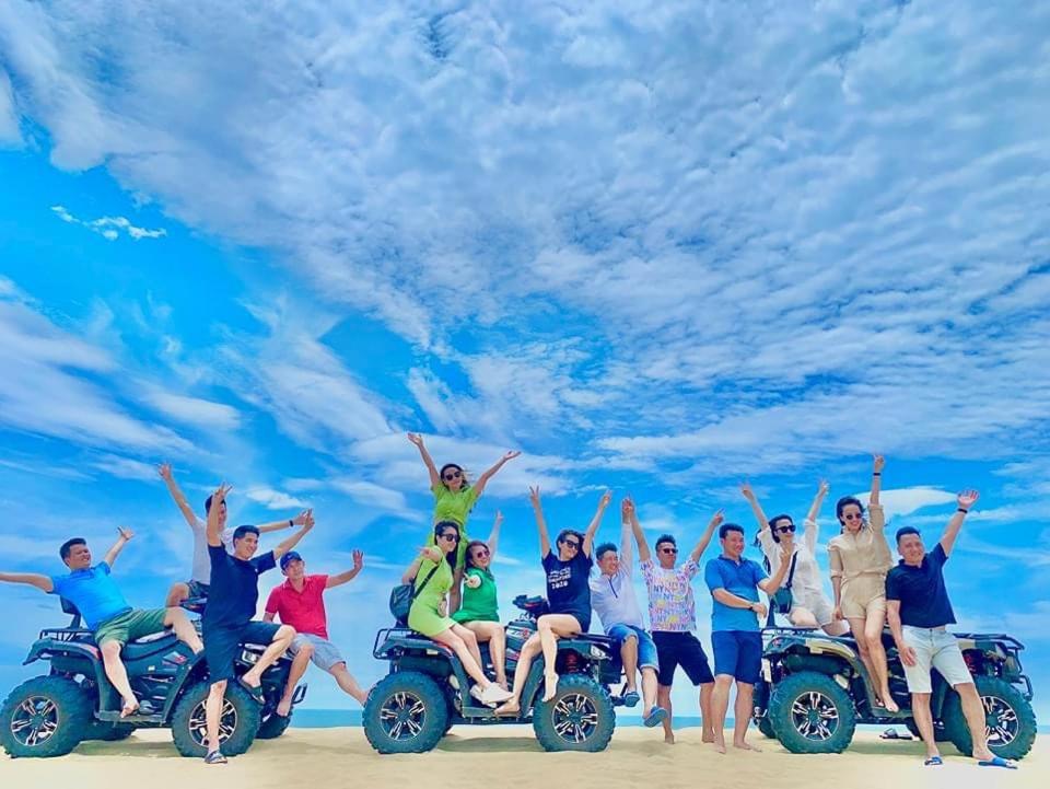 un grupo de personas sentadas sobre cuatro ruedas en la playa en Sea Star Resort en Ðồng Hới