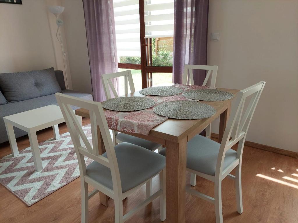 uma mesa de jantar com quatro cadeiras e um sofá em Apartamenty Zdrojowe em Nałęczów