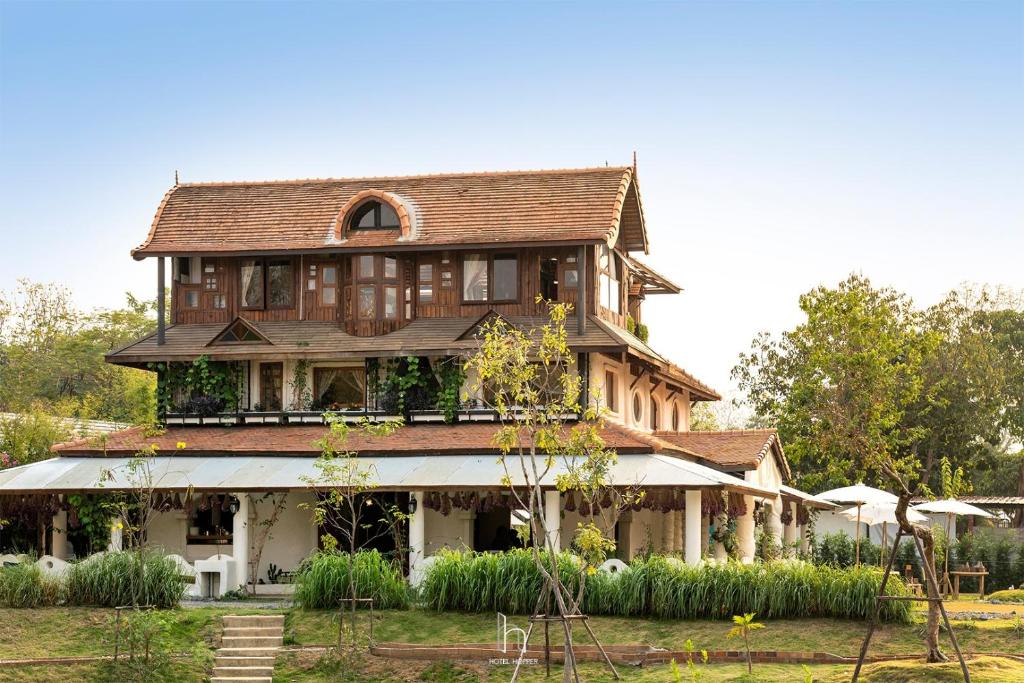 uma grande casa de madeira com telhado em Naturetalk Homestay em Ban Don