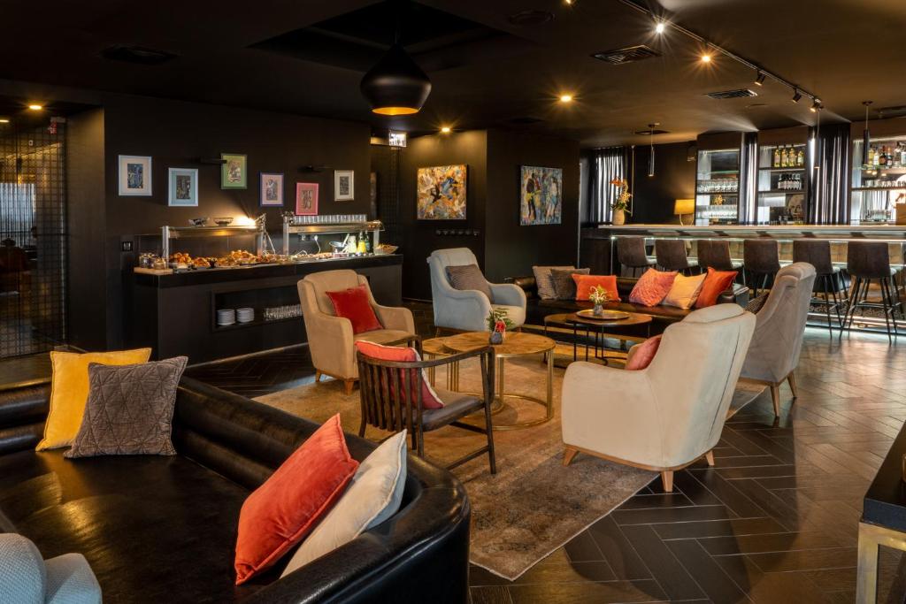 un ristorante con divani e tavoli e un bar di Leonardo Boutique Rehovot a Rechovot