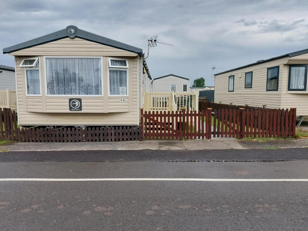 a house with a fence in front of it at 95 Holiday Resort Unity 3 bed passes included in Brean