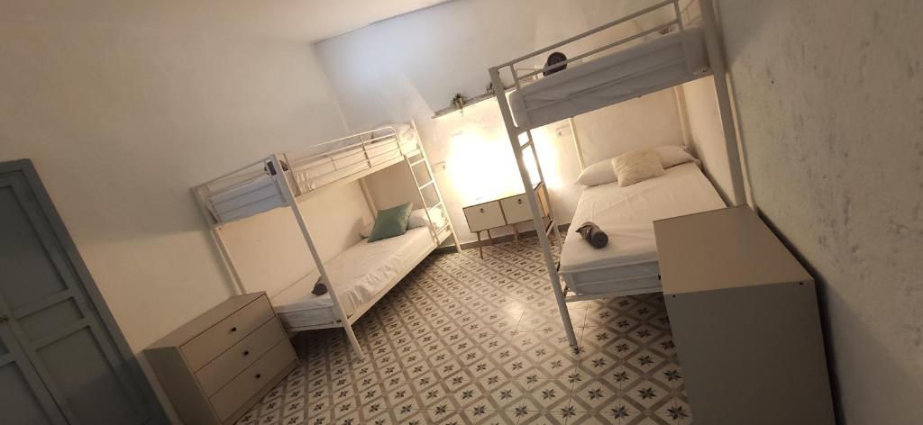 TahalにあるLos Siete Encantosの二段ベッド2台、デスクが備わる小さな客室です。