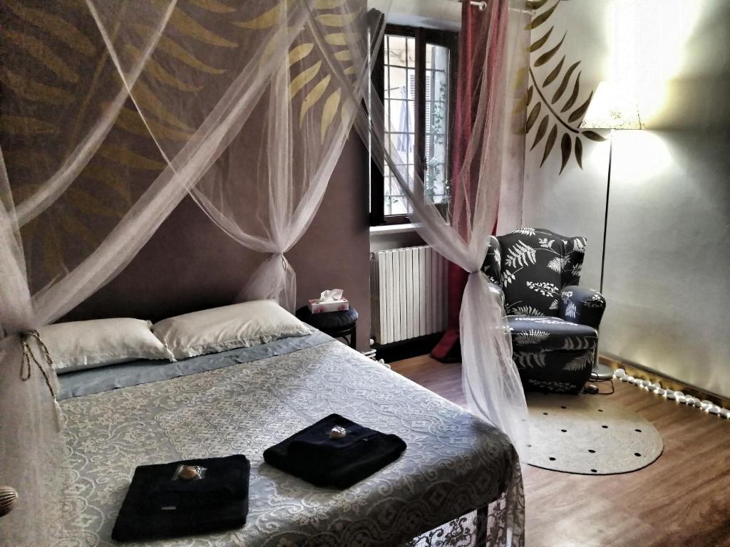 een slaapkamer met een bed met twee zwarte handdoeken erop bij RaMaya casa d'artista 2 THE ROOM in Biella