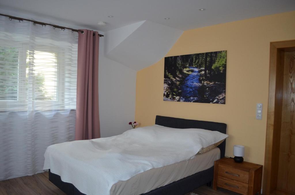 1 dormitorio con 1 cama y una pintura en la pared en Ferienhaus Köhler en Marienberg