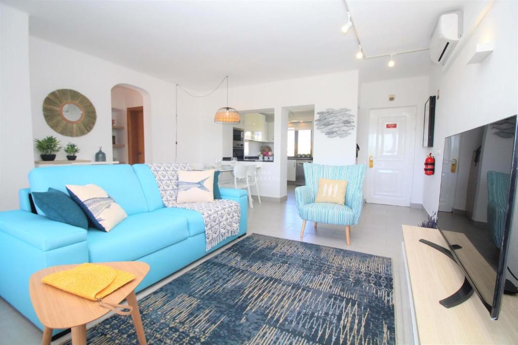 Il comprend un salon avec un canapé bleu et une cuisine. dans l'établissement Sao Rafael Beach Apartment - By Dalma Portuguesa, à Albufeira