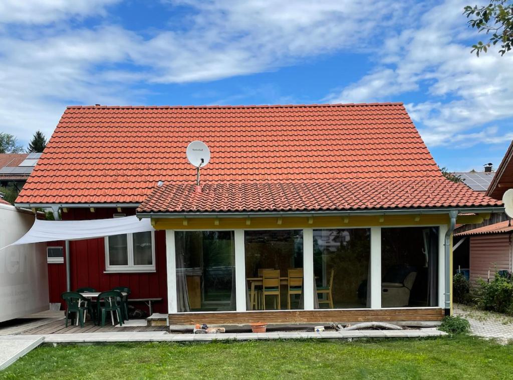una casa con techo naranja y patio en Ferienhaus Stefanie, en Bernbeuren