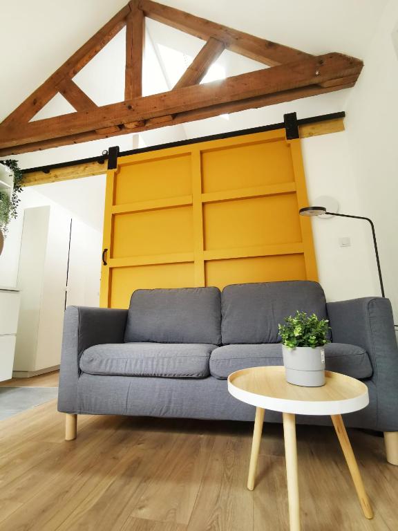 un salon avec un canapé bleu et une table dans l'établissement Au Mexico (Centre - Gare - Atypique - Parking), à Béthune