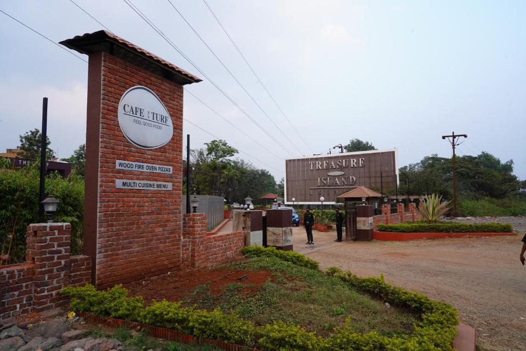 a brick building with a sign on it next to a street at Treasure Island Resorts Lonavala in Lonavala