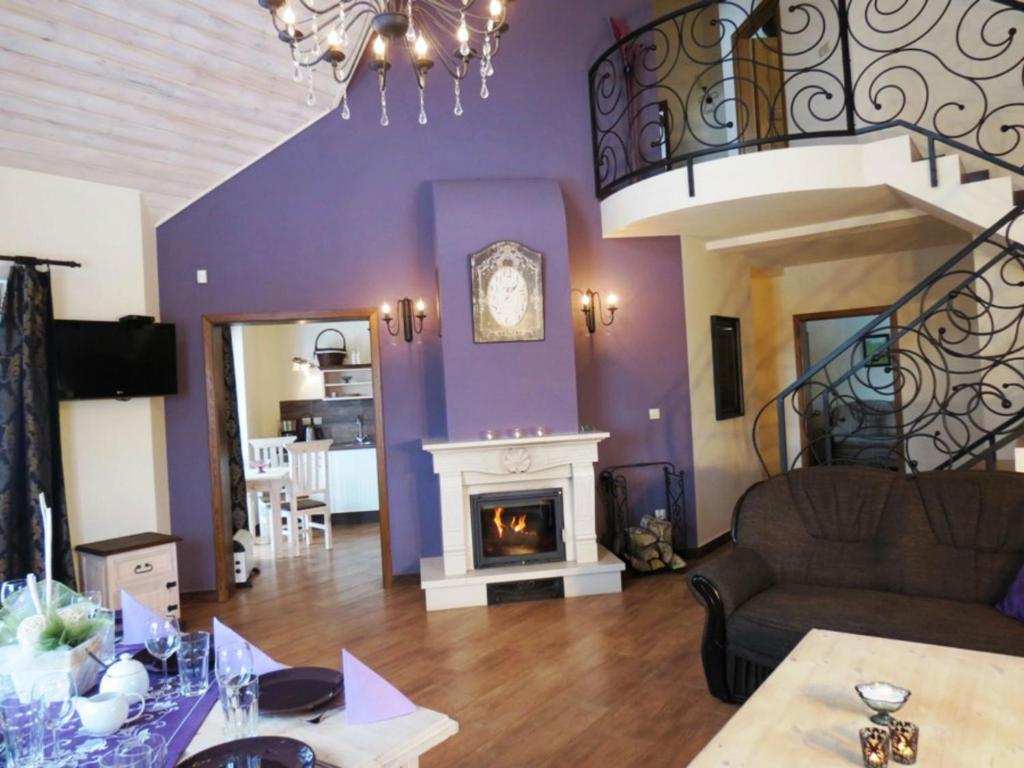 a living room with purple walls and a fireplace at Zielone Wzgórza in Bytów