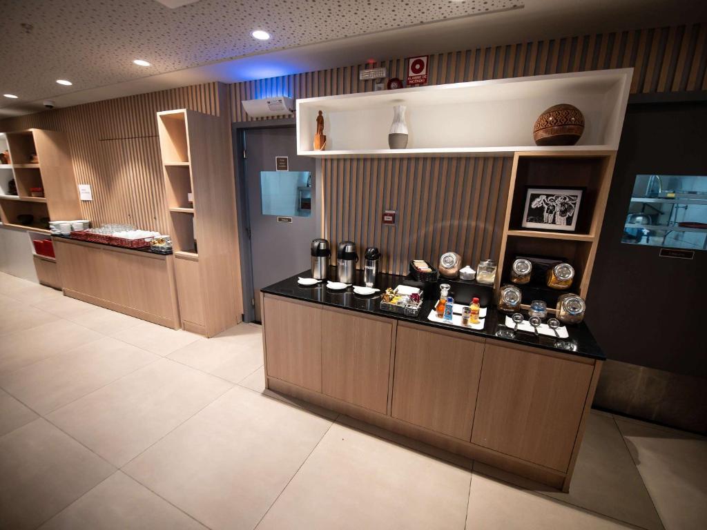 a restaurant with a counter with bottles on it at ibis Juazeiro do Norte in Juazeiro do Norte