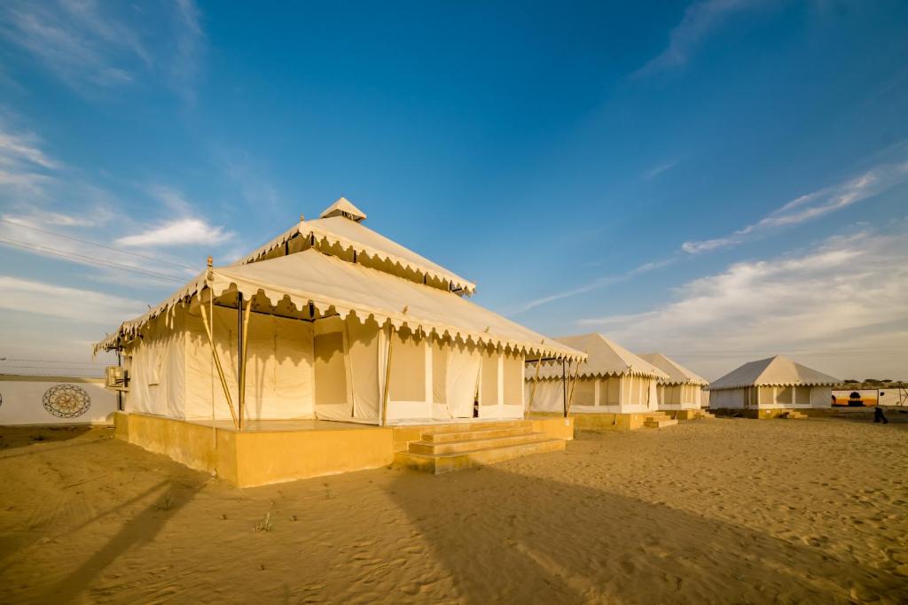 a row of white tents on a sandy beach at Bhavya Resort - Luxury Boutique Desert Camp in Jaisalmer