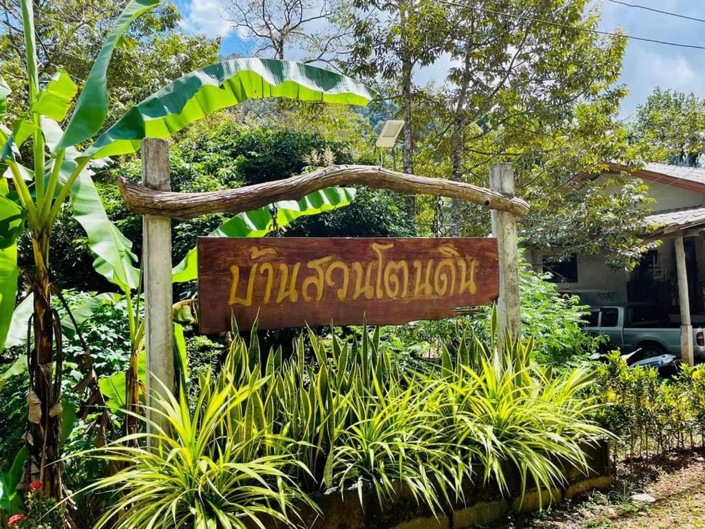 a sign in a garden in front of a house at Baan Suan Tondin 