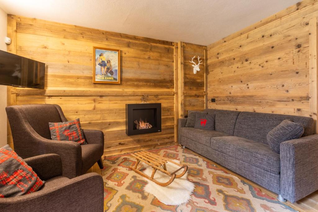 a living room with a couch and a fireplace at Maison La Louche - Courmayeur in Courmayeur