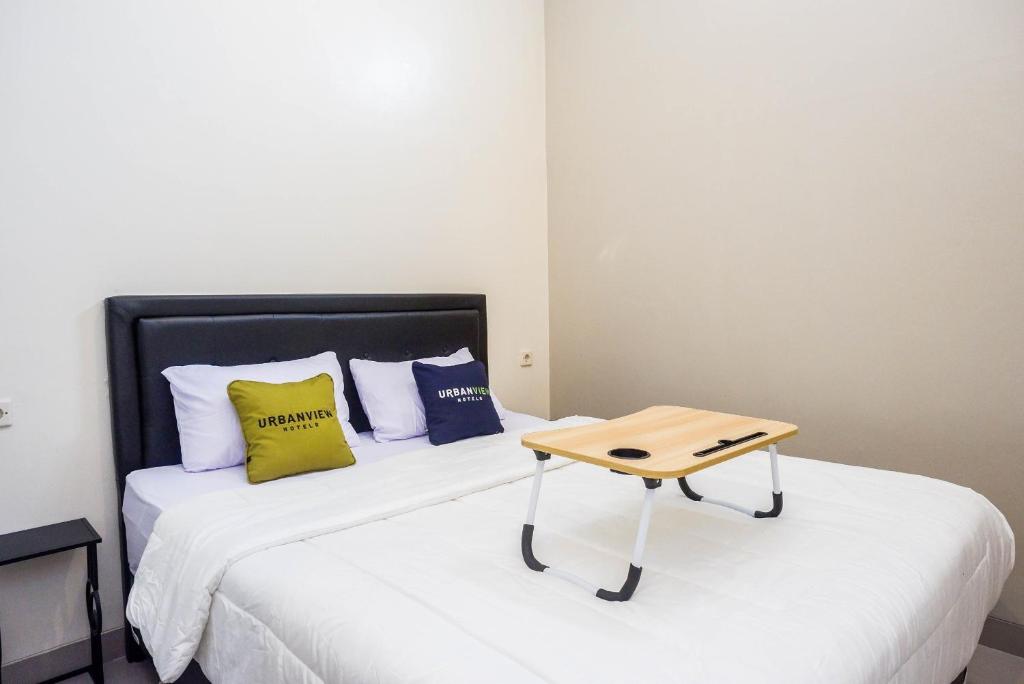 una camera da letto con un letto e un tavolo sopra di Urbanview Hotel Syariah John Sweet Home by RedDoorz a Tegal