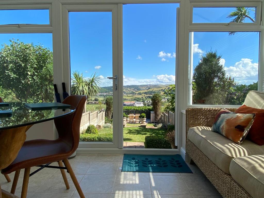a living room with a couch and a window at Llandudno Boutique style seaside retreat with stunning views in Llandrillo-yn-Rhôs