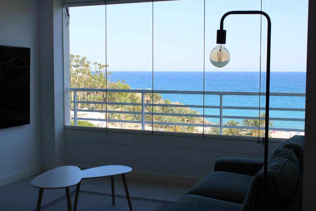 salon z dużym oknem z widokiem na ocean w obiekcie Panoramic Suite Beach w mieście Villajoyosa