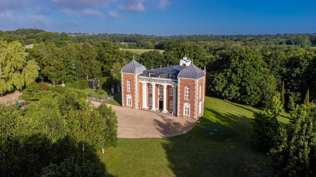 an aerial view of a large brick house on a field at Eastwood Observatory: 12 bedrooms, swimming pool and tennis court in Hailsham