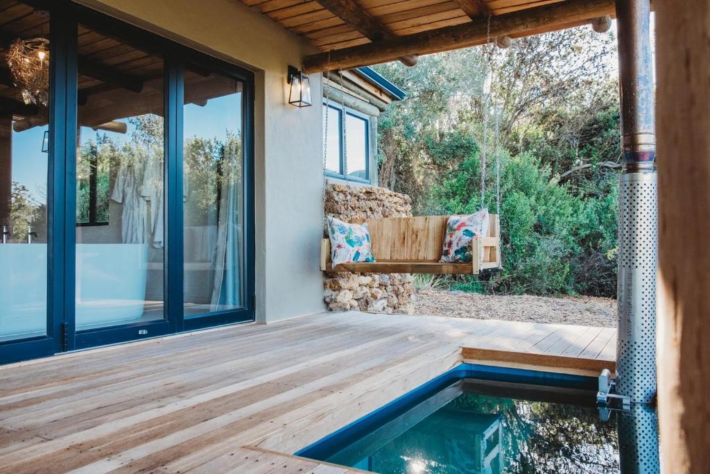 une terrasse en bois avec une piscine dans une maison dans l'établissement De Uijlenes, à Gansbaai
