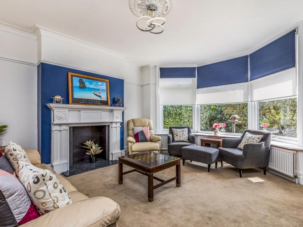 a living room with blue walls and a fireplace at Pass the Keys Spacious Beach Holiday Home For Friends Family in Bognor Regis