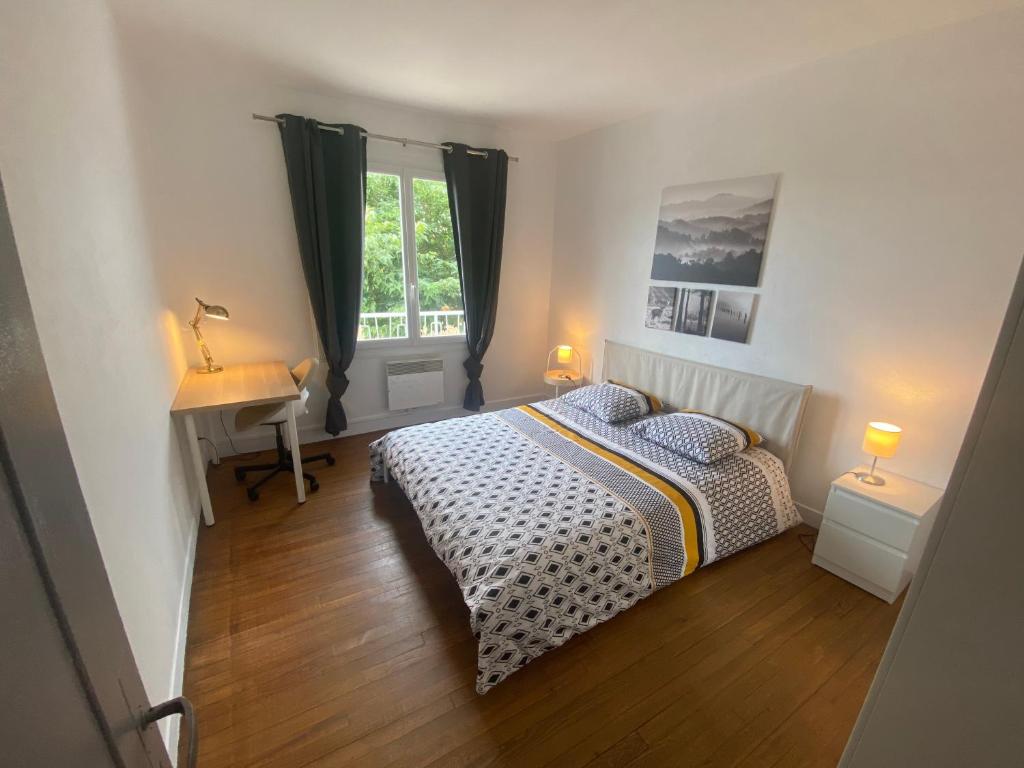 Schlafzimmer mit einem Bett, einem Schreibtisch und einem Fenster in der Unterkunft Fabuleux T3 de 85 m2, situé au calme avec grand parking gratuit privé ,Fibre wifi in Saint-Gaudens