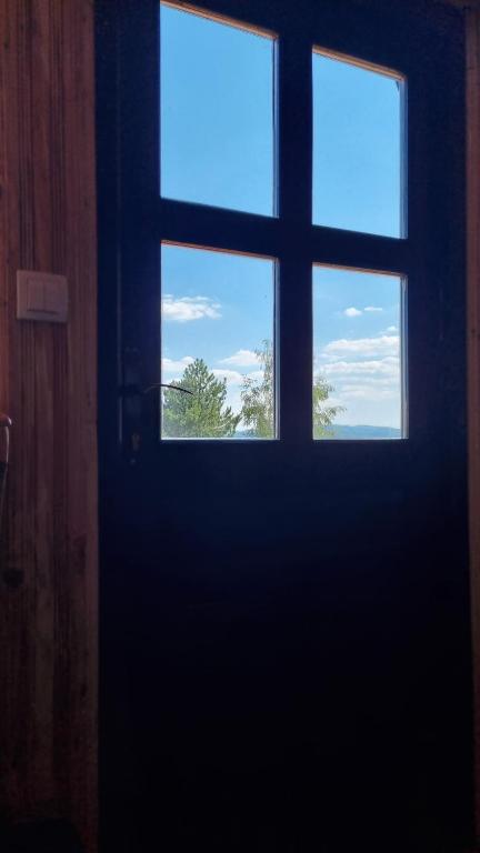 a door with three windows in a room at A Pine vikendica u srcu Zapadne Srbije in Nova Varoš