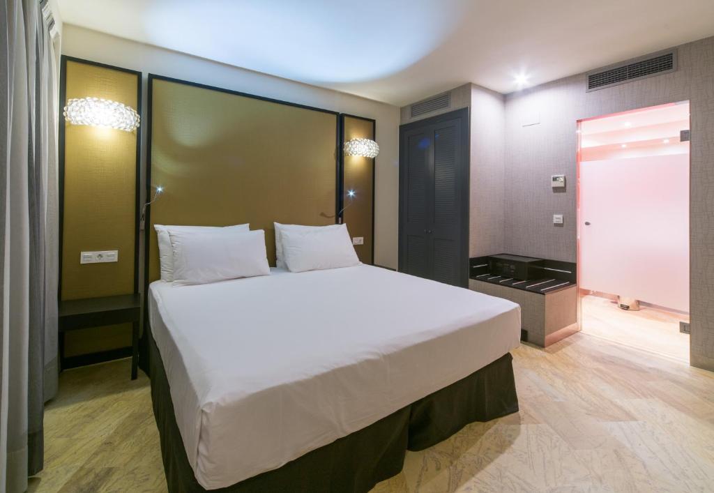 a bedroom with a large white bed in a room at Hotel Palacio Marqués de Arizón in Sanlúcar de Barrameda