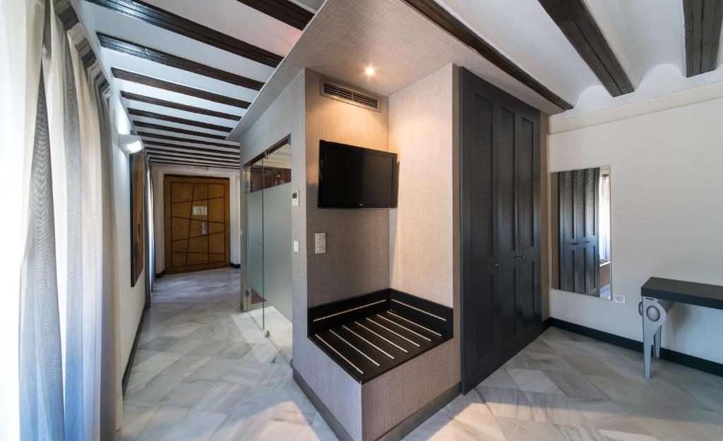 a hallway with a flat screen tv on a wall at Hotel Palacio Marqués de Arizón in Sanlúcar de Barrameda