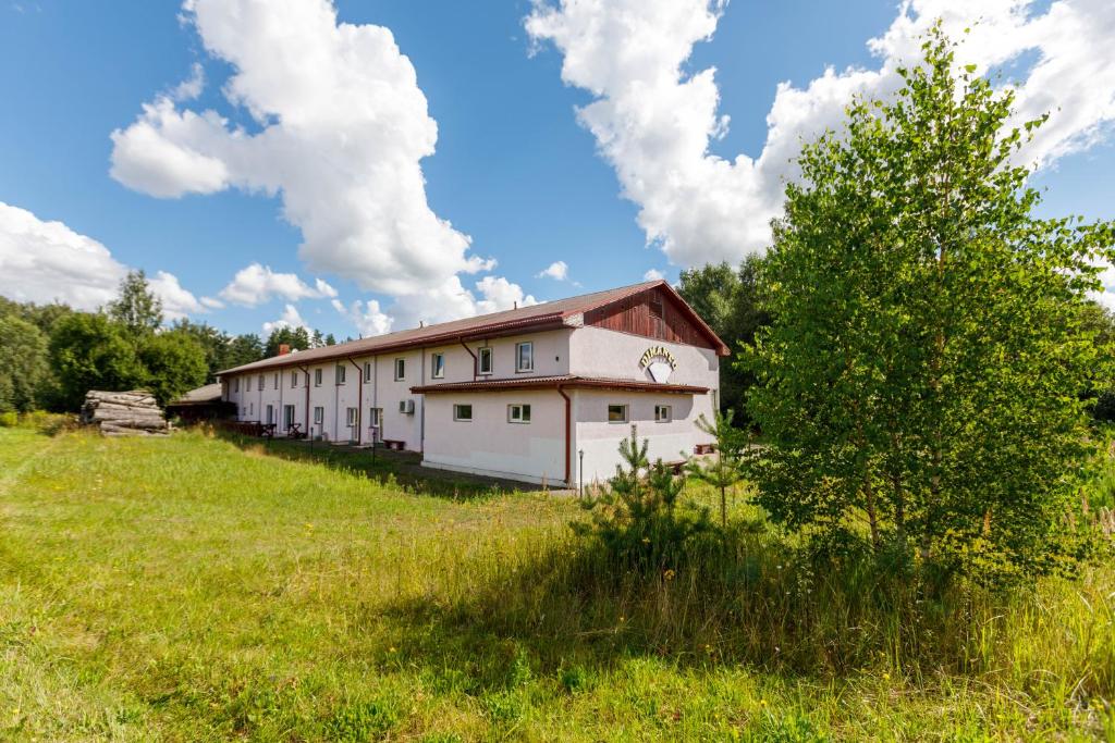 un bâtiment au milieu d'un champ dans l'établissement Viesu nams “Dimantu ferma”, à Ikšķile