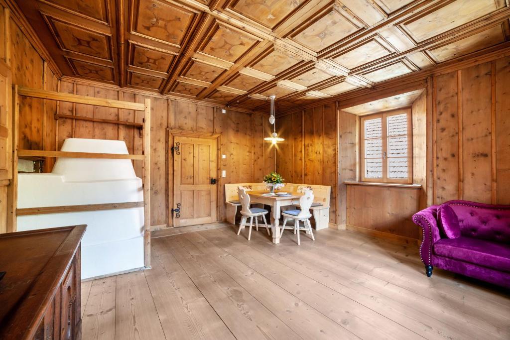 a dining room with a table and a purple couch at Unterlanpacher Historic Refugium in Laces