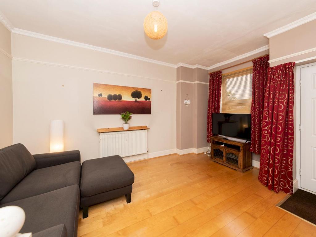 a living room with a couch and a television at Pass the Keys Spacious 1 bed Flat Close to Central Location in Reading